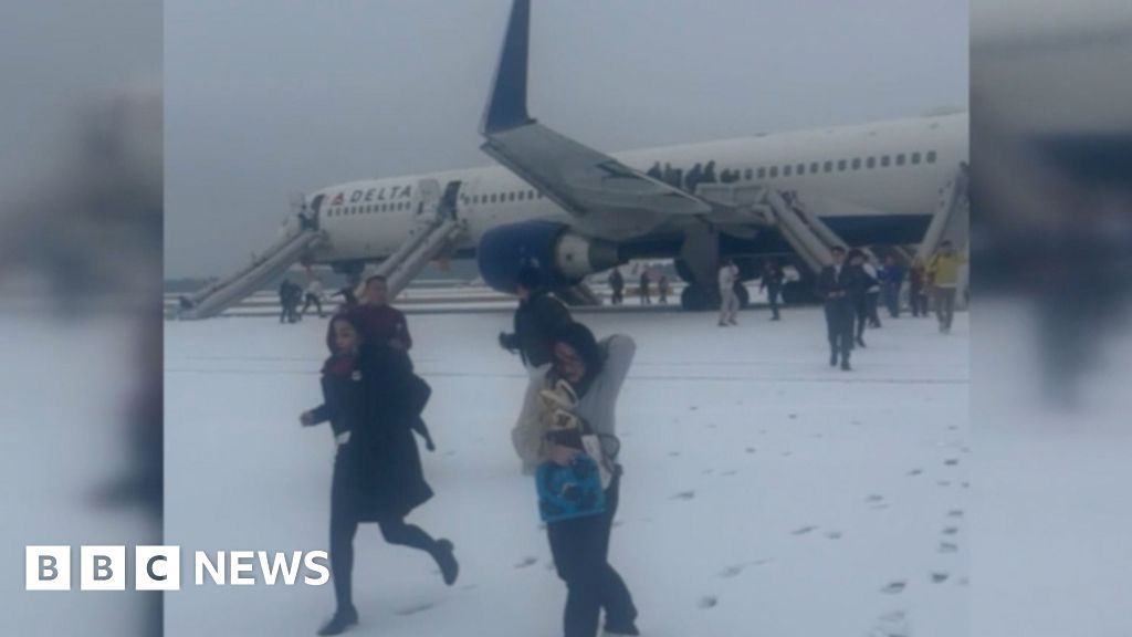 Passengers evacuate plane on snowy tarmac amid storm