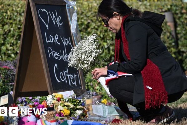 Individuals wave goodbye to US president Jimmy Carter